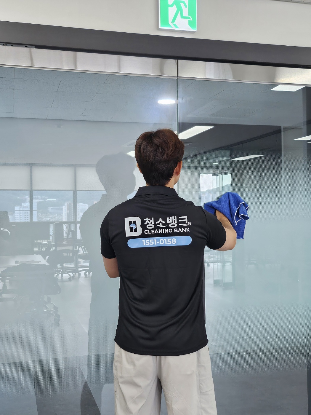 사무실 유리문과 파티션을 닦는 작업 장면